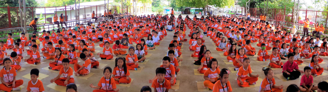 Children and young people seated together during a large Ananda Marga gathering